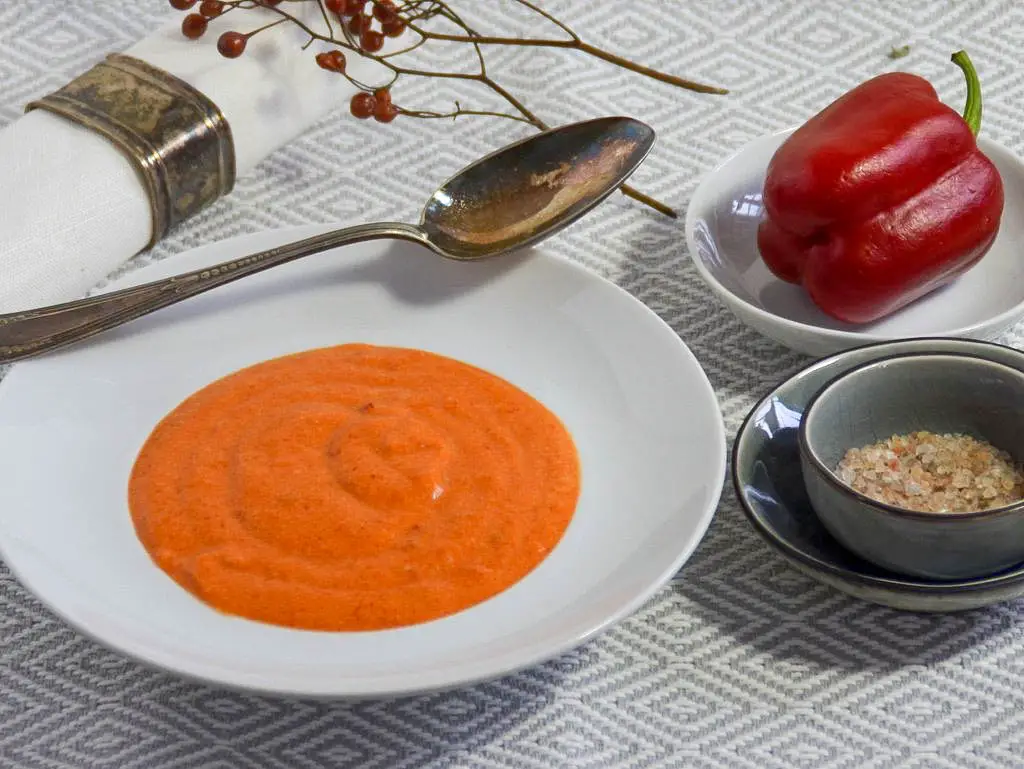 Teller mit einer cremigen Suppe aus rotem Paprika